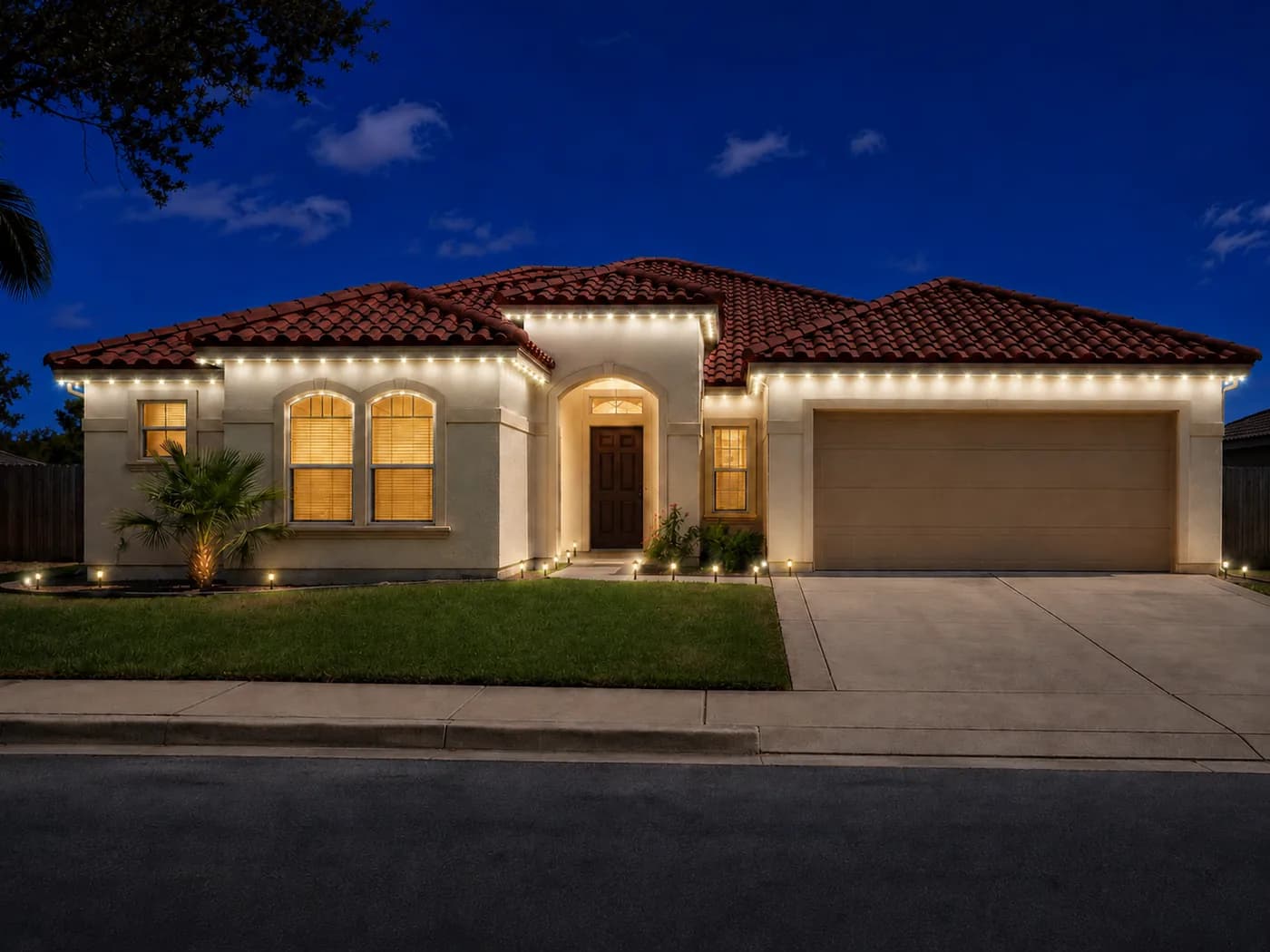 Spanish-style home with roofline lighting and path lights