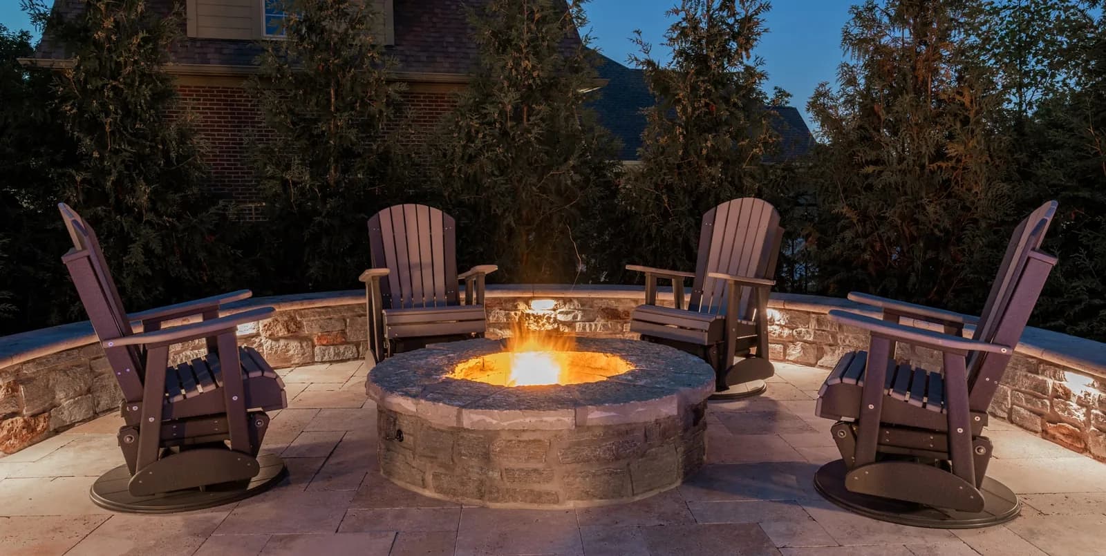 Patio fire pit with warm landscape lighting